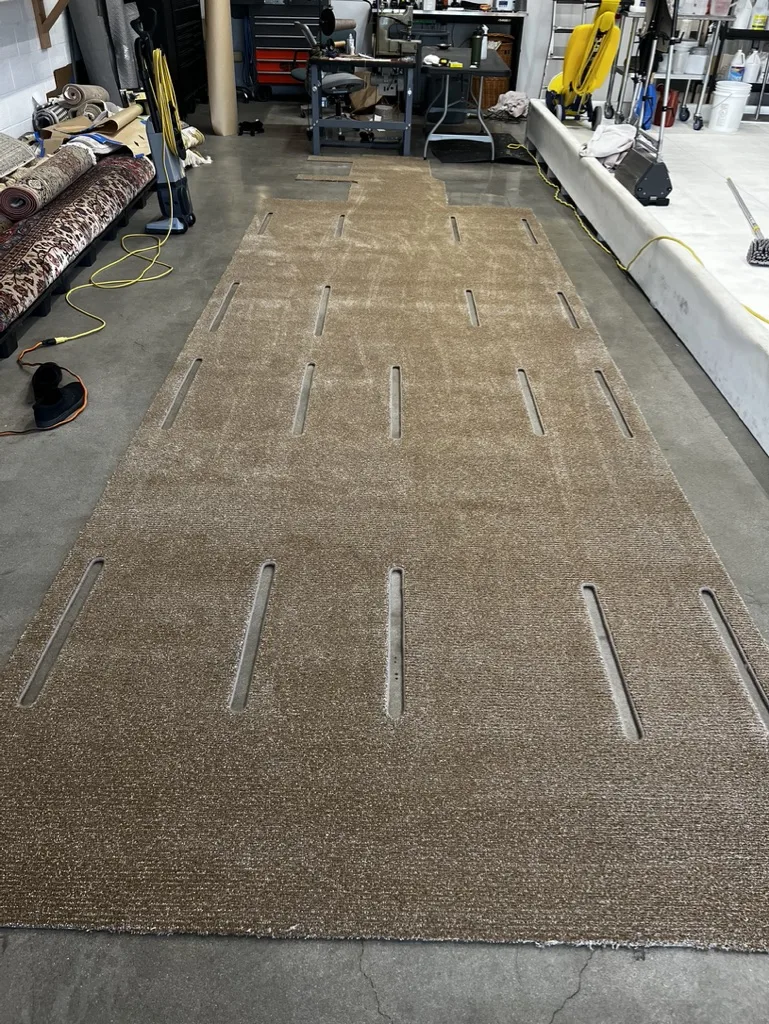 A finished aircraft aisle runner with bound edges and hardware cutouts