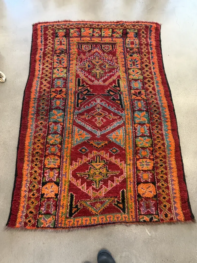 A red Berber Moroccan rug with geometric medallions at the Fiber Specialties Boise shop