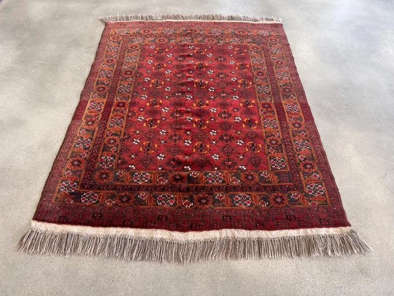 A red hand-knotted Bokhara design rug with its fringe replaced by hand in Boise