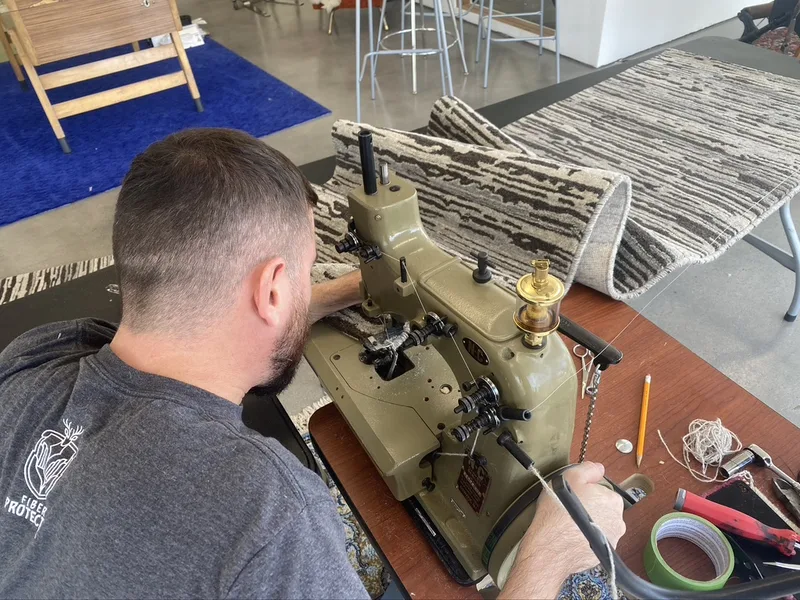 A rug edge being serged on the machine at the Fiber Specialties Boise shop