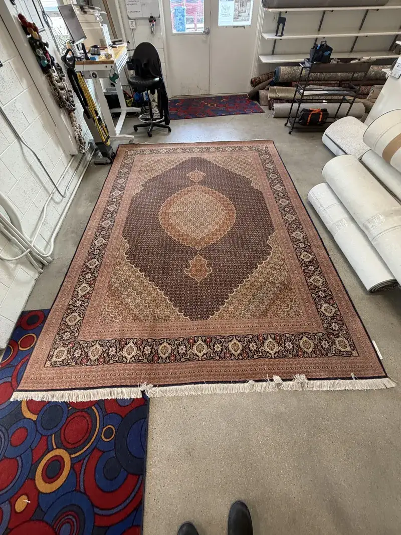 A Mahi Tabriz Persian rug checked in for cleaning at the Fiber Specialties Boise shop