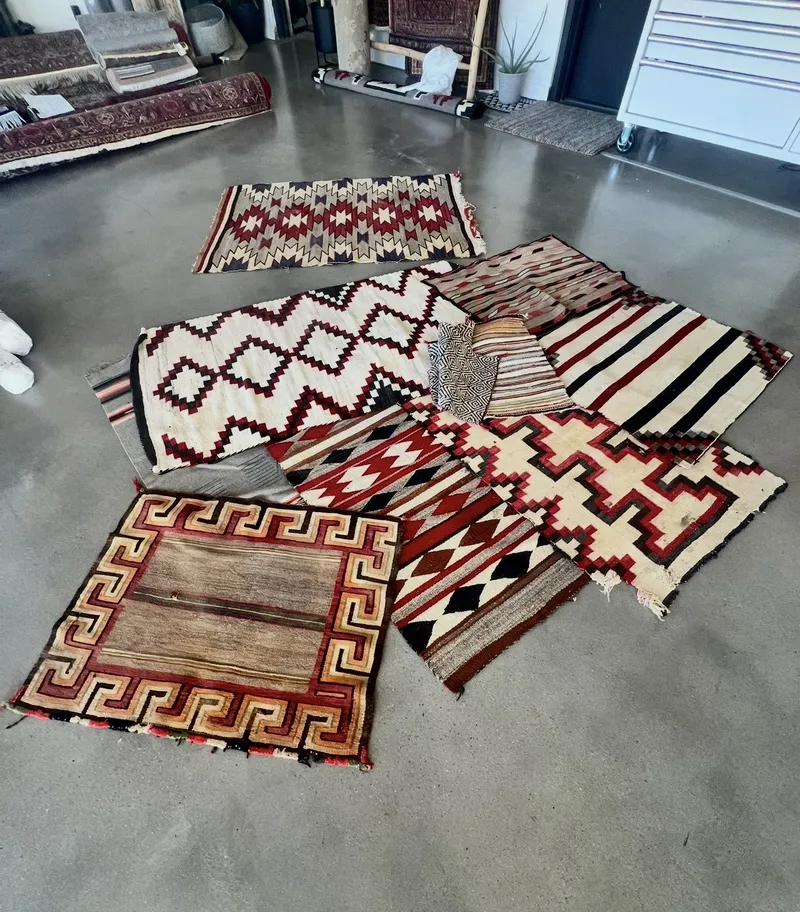 A stack of Navajo weavings checked in together at the Fiber Specialties Boise shop