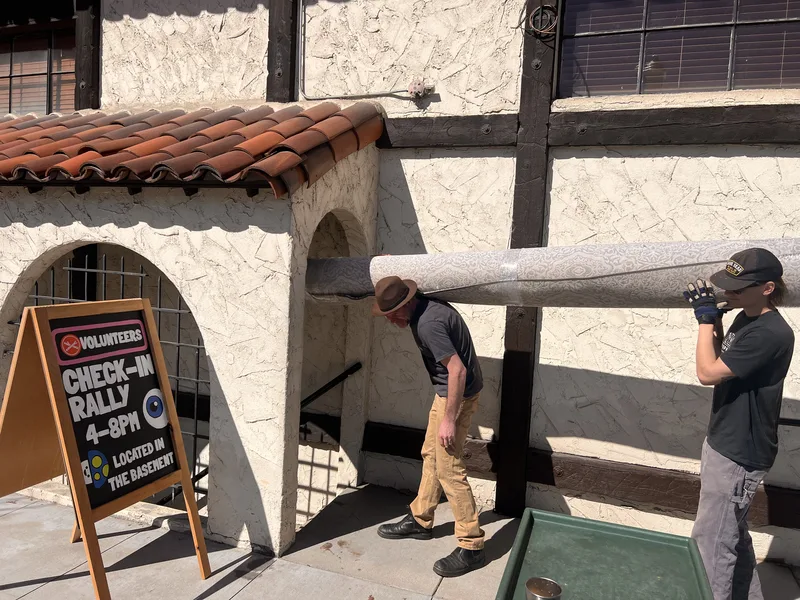 A Fiber Specialties technician carrying a rolled rug past the Basque Center in downtown Boise