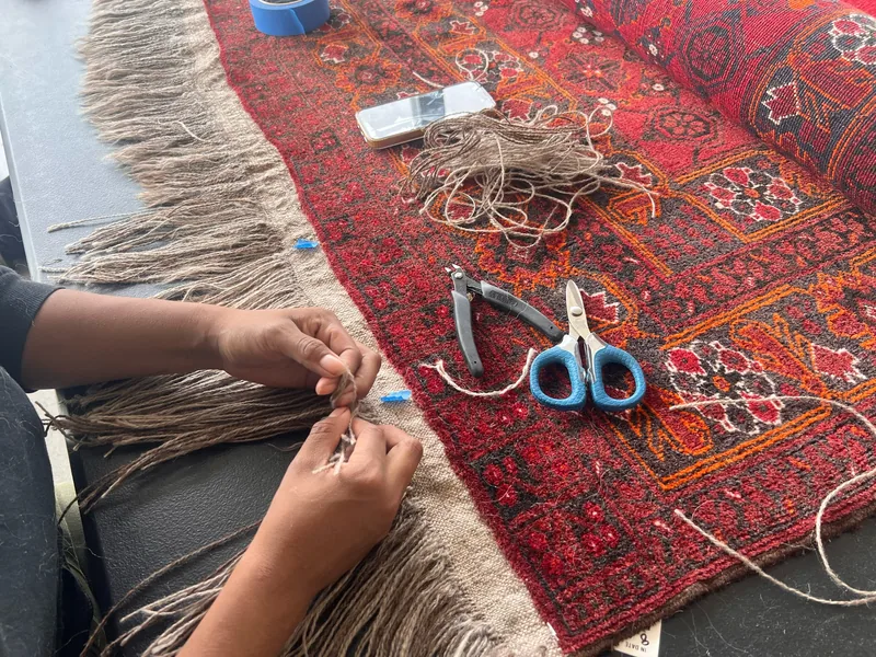 Hand repair work on the knotted end of a rug at the Fiber Specialties Boise facility