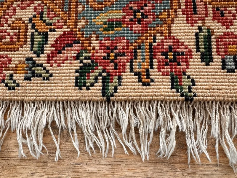 Close-up of a rug end where the securement stitch holds the foundation warps, the point edge damage usually starts