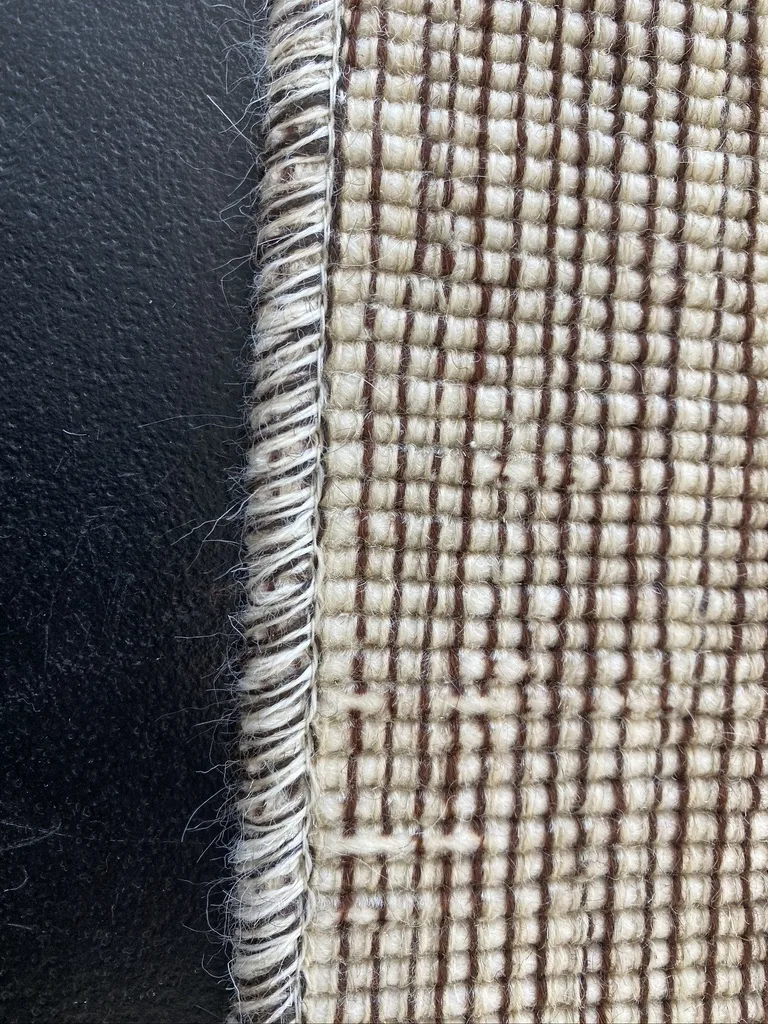 A freshly serged wool rug edge up close at the Fiber Specialties Boise shop