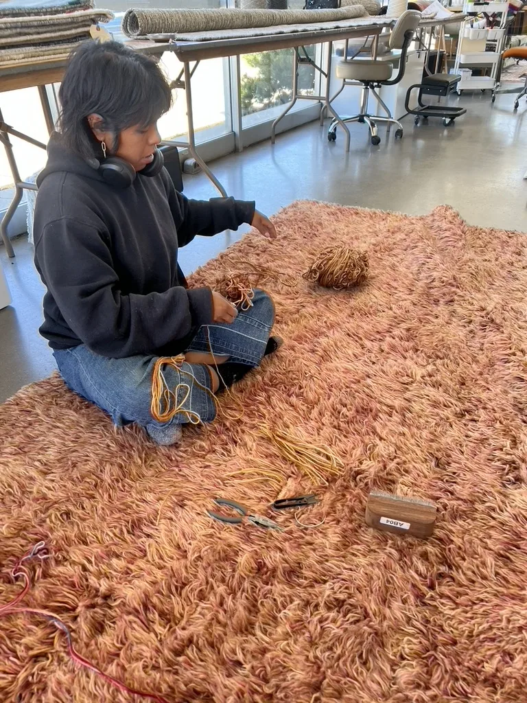 A technician rebuilding eaten pile by hand, knot by knot, at the Fiber Specialties repair bench