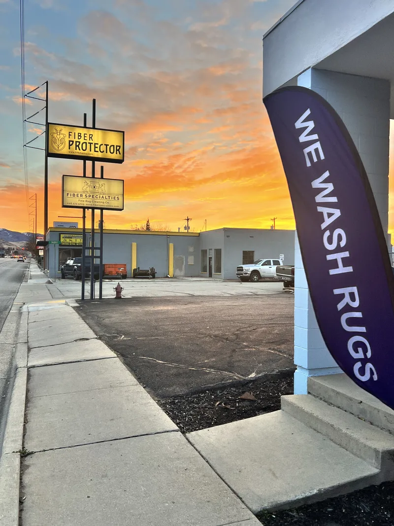 We Wash Rugs flags outside the Fiber Specialties shop on W Overland Rd in Boise at sunset