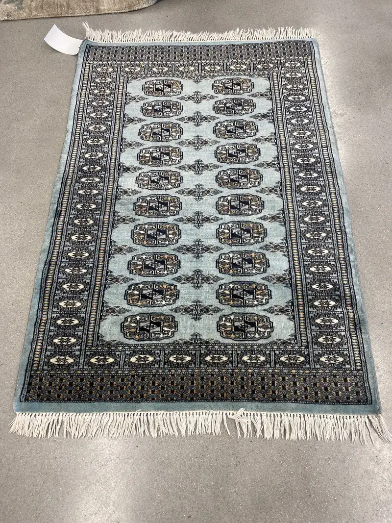 A teal Pakistani Bokhara rug at the Fiber Specialties Boise shop