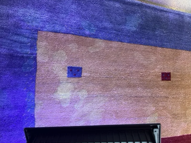 Urine spots glowing under UV light inspection on a rug at the Fiber Specialties Boise facility