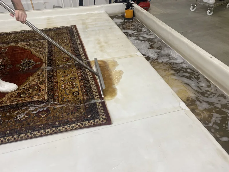 Dirty wash water squeegeed out of a rug during a full-immersion wash at the Fiber Specialties Boise facility