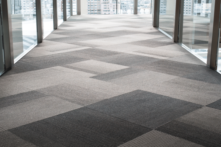 A well-lit hallway with a large window and ample floor space, emphasizing the need for effective business carpet maintenance.