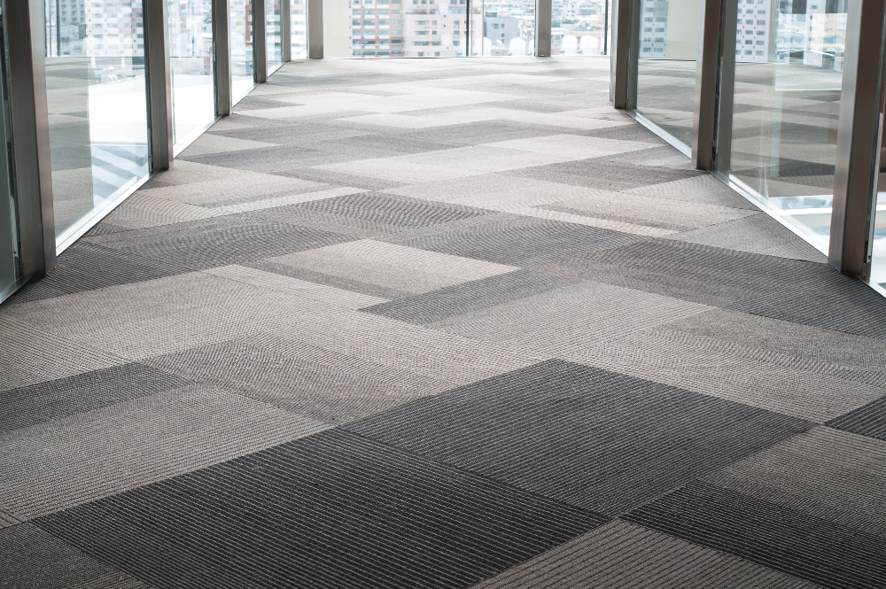 A well-lit hallway with a large window and ample floor space, emphasizing the need for effective business carpet maintenance.