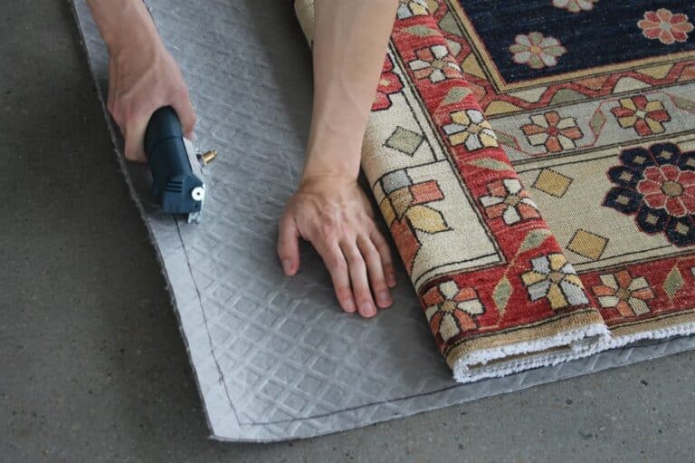 An individual utilizes a power tool to cut a rug, showcasing craftsmanship and attention to detail in the process.