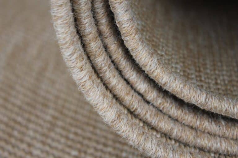 A close-up view of a beige rug, showcasing its soft texture and subtle color variations.