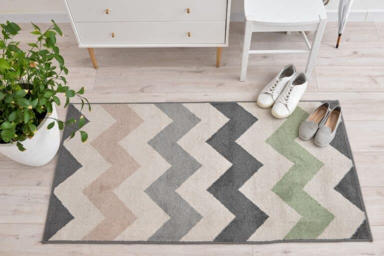 A small and colorful rug on a hardwood floor showing the importance of rug pad selection.