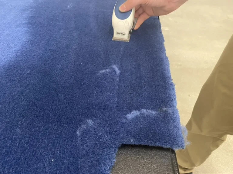 Hand carving the pile of a blue Gulfstream cabin carpet during restoration