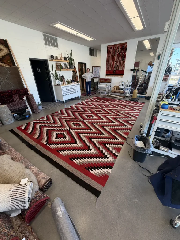 An oversized war-effort Navajo eyedazzler rug laid out across the Fiber Specialties showroom floor in Boise