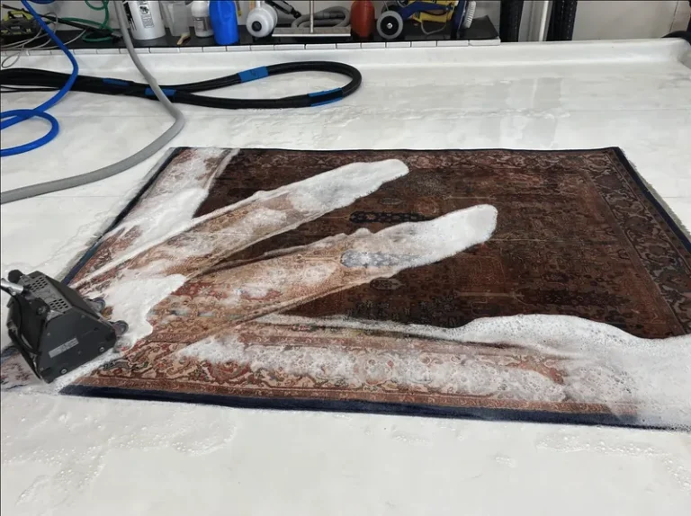 A rug fully submerged and hand-washed in suds on the wash floor at the Boise facility
